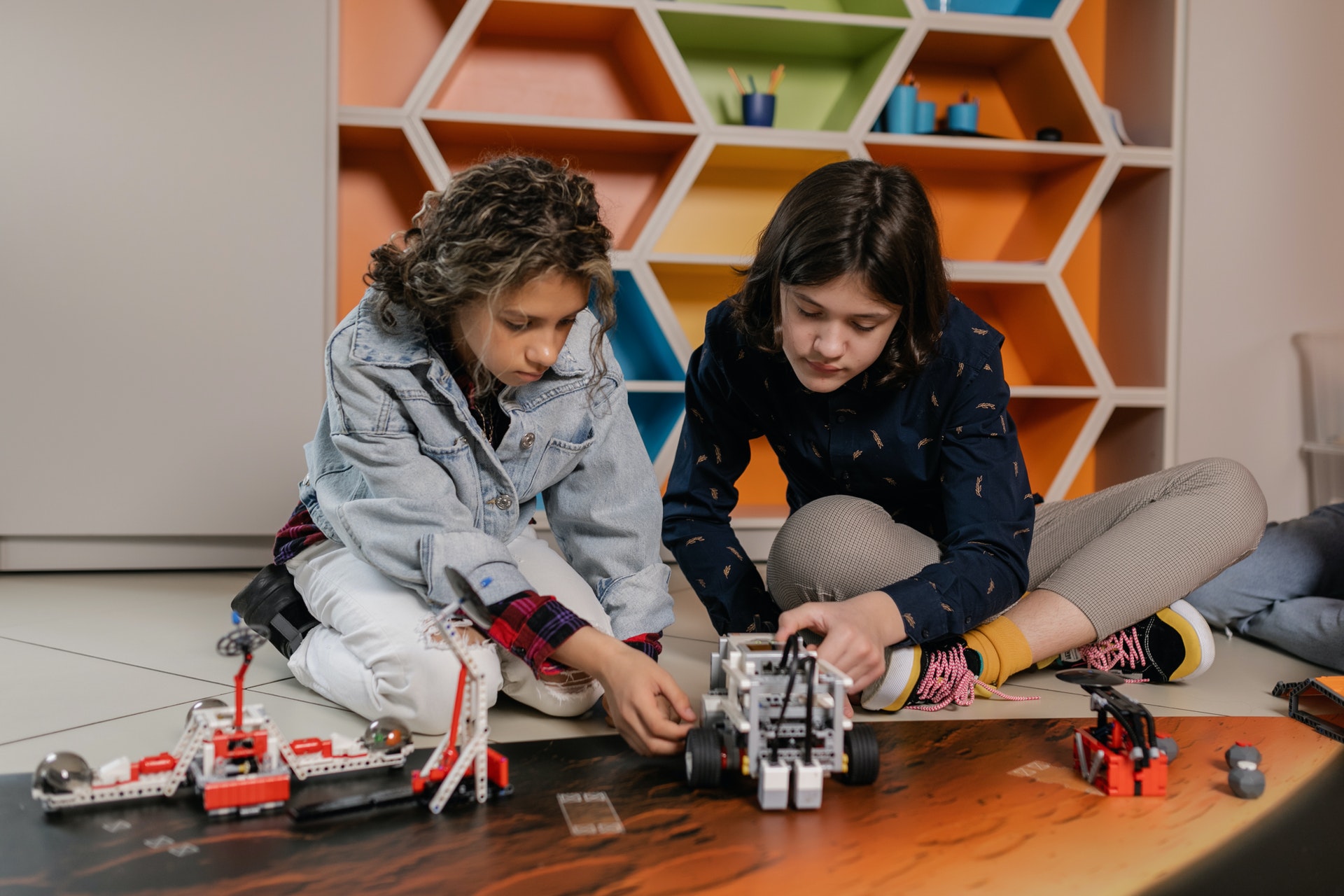 Adolescentes montando um robô em uma sala de aula. Imagem ilustrativa do texto curso de robótica e programação infantil.