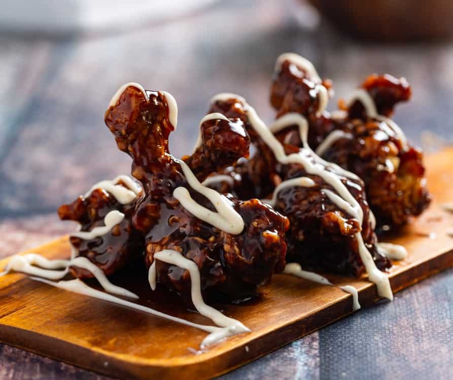 coxinhas de frango frito em uma tábua com molho