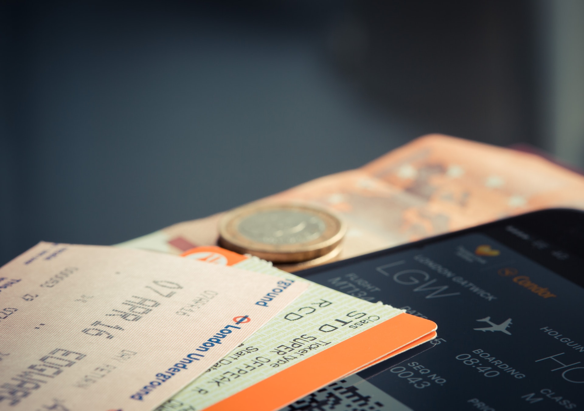 Duas passagens aéreas com uma moeda e nota de dinheiro perto. Imagem ilustrativa do texto dicas de empreendimentos.