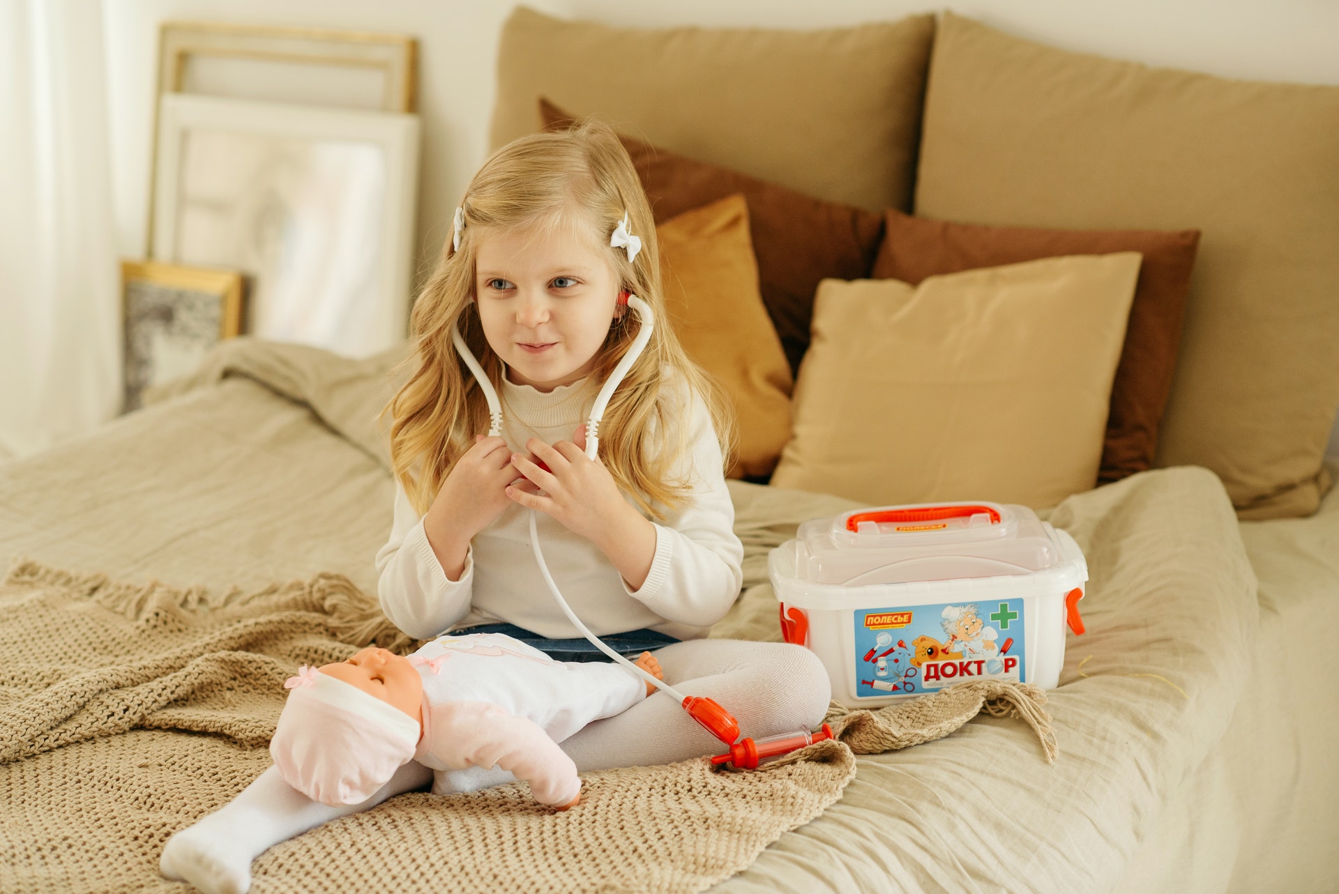 Criança com brinquedos em cima de uma cama. Imagem ilustrativa do texto sobre negocios online.