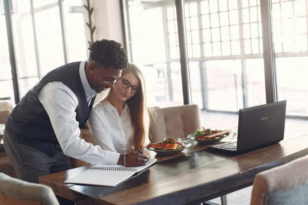 homem e mulher olhando anotações em uma mesa. Imagem ilustrativa do texto sobre suporte ao franqueado