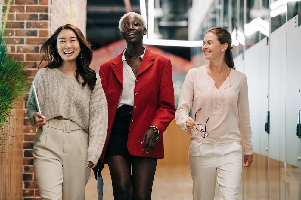 Mulheres sorridentes andando em corredor com piso marrom. Ilustração do texto sobre dicas de empreendimentos.
