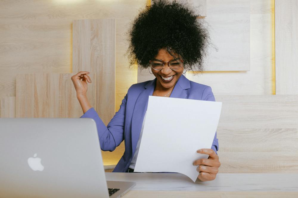 Mulher sorridente trabalhando em um notebook cinza. Ilustração do texto sobre investimento online seguro.