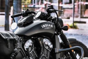 Imagem de uma moto com a estrutura preta e um escrito em branco "Indian". Imagem ilustrativa texto franquia de motopeças.
