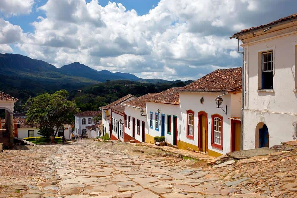 rua de pedra de cidade pequena com casas com fachadas coloridas ilustração de franquias baratas para cidades pequenas