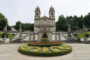Vista de igreja com jardim verde a frente. Ilustração do texto sobre negócios rentáveis em Portugal.