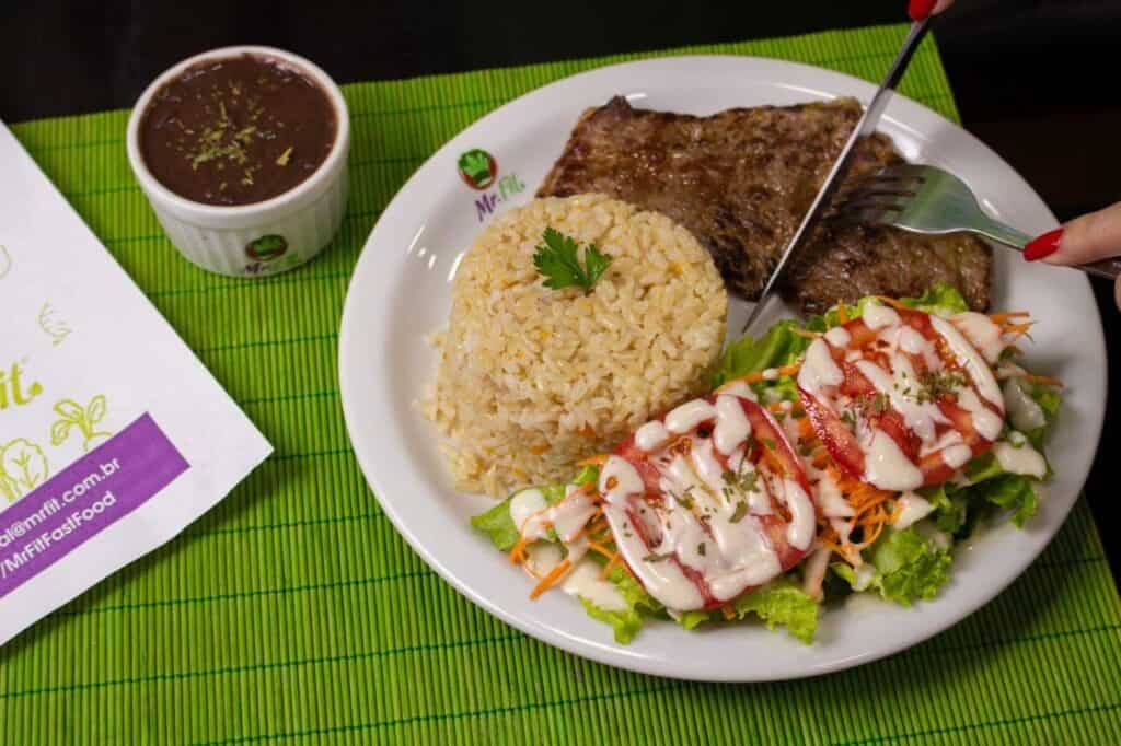 Refeição completa Mr. Fit em um prato, com arroz, carne e salada.